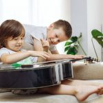 Bambini che suonano una chitarra acustica - strumenti musicali