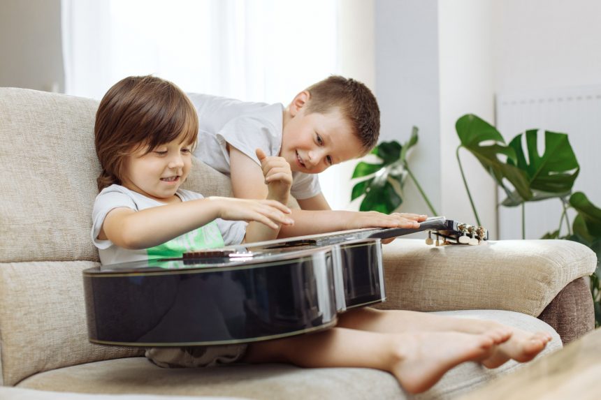 Children Playing an Acoustic Guitar - Musical Instruments Children Playing an Acoustic Guitar - Musical Instruments
